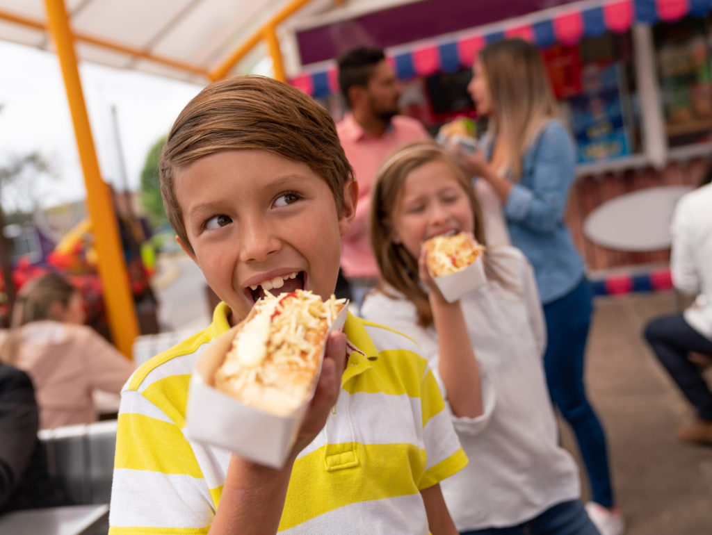 kids enjoying a hot dog during spring break in myrtle beach at the annual food truck festival