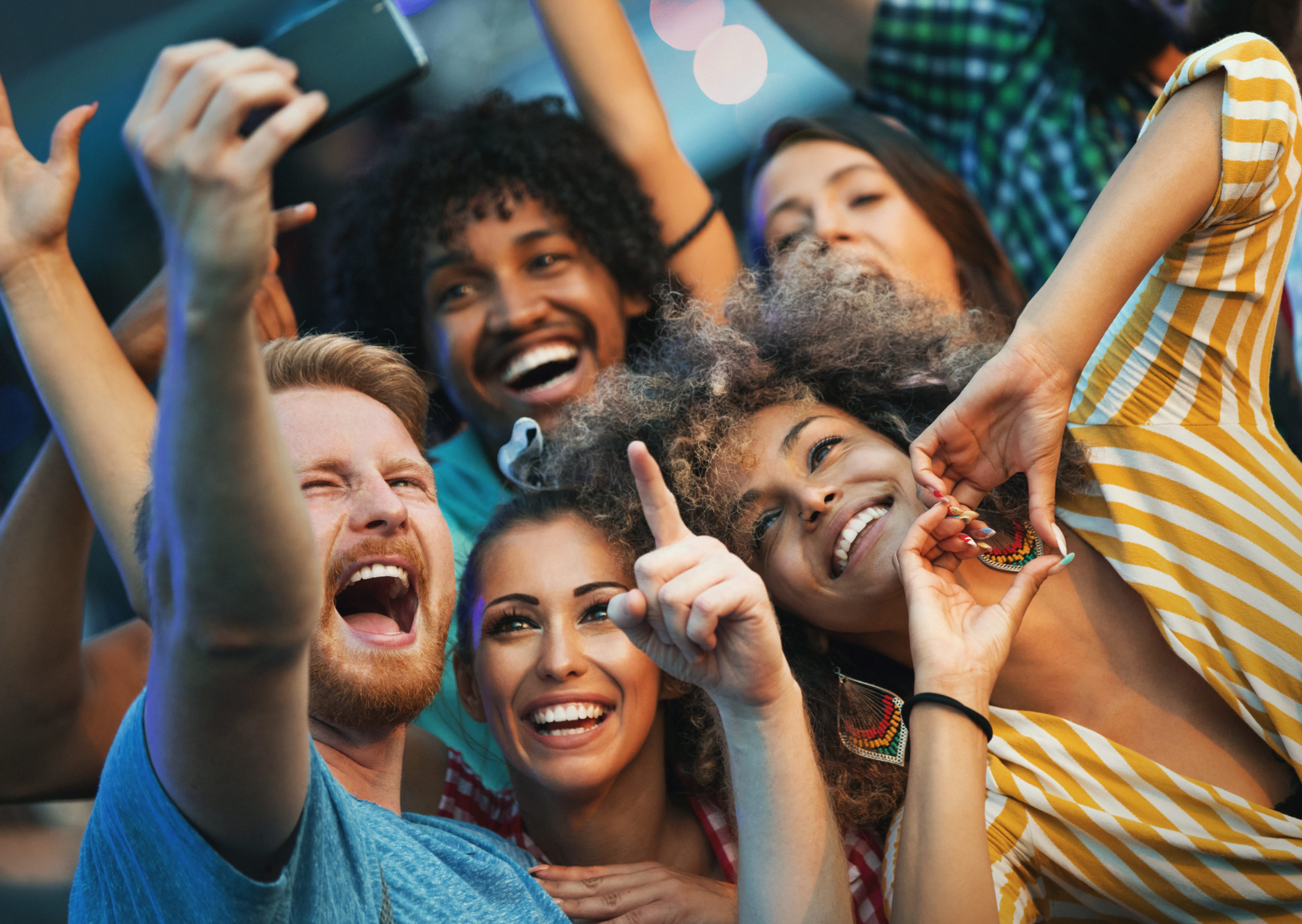 Closeup of group of multi ethnic young adults taking some selfies at CCMF Myrtle Beach.