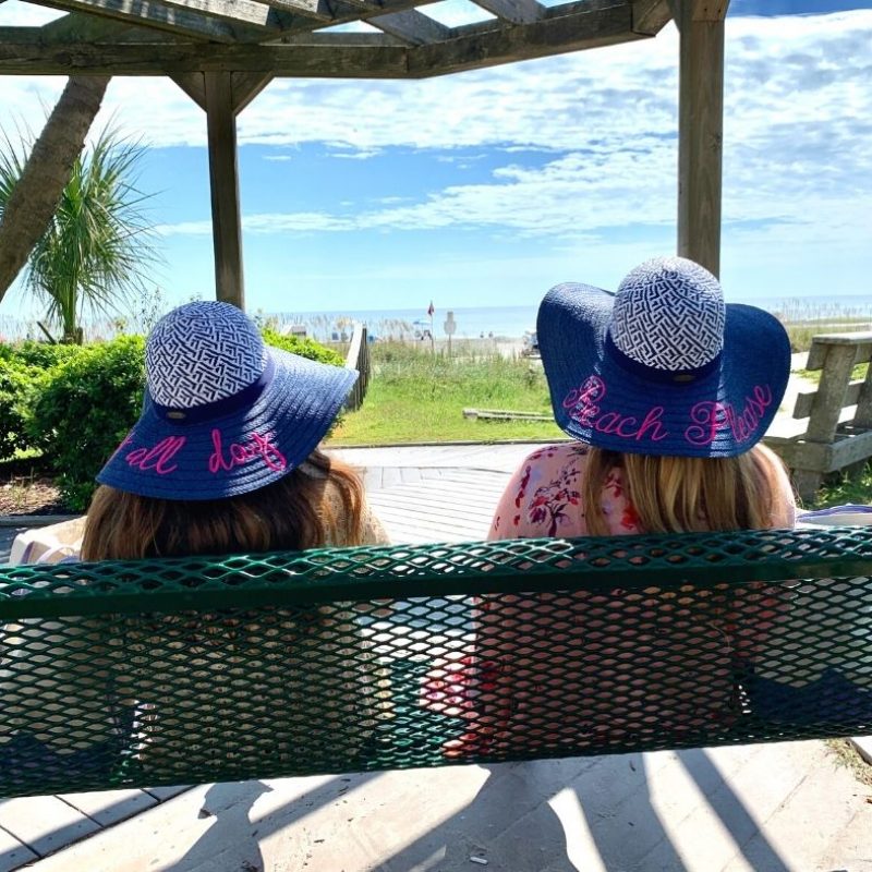 Two girls sitting on an oceanfront swing